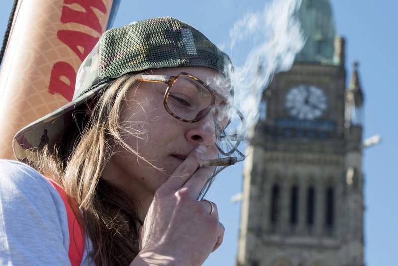 A woman smokes a joint during the annual 420 marijuana rally on Parliament Hill